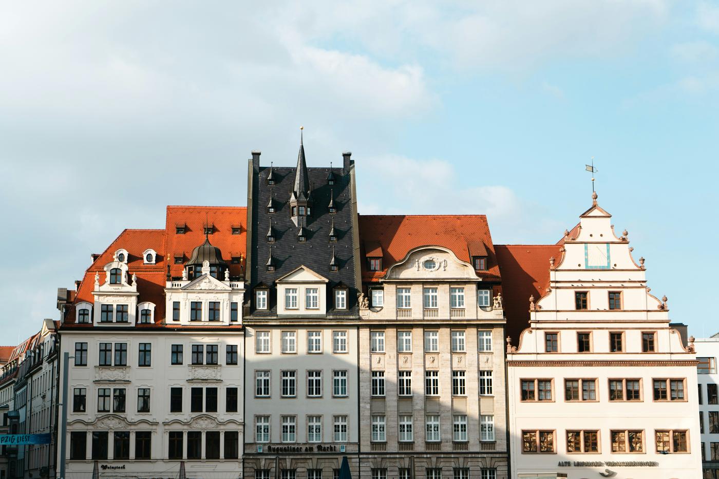 Historische Häuser mit roten und schwarzen Dächern am Markt in Leipzig / Historic buildings with red and black roofs on the Markt square in Leipzig